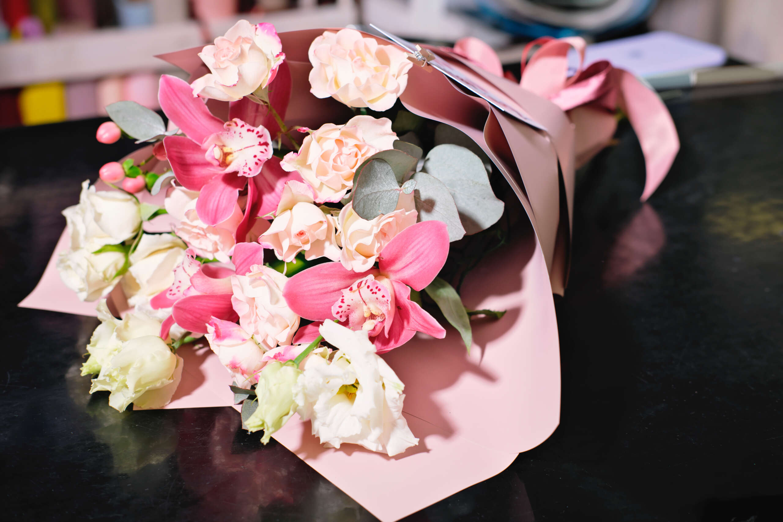 delicate pink flowers, bouquet in a wrapping on a florist shop table. festive gift for holiday or birthday. Valentines day present